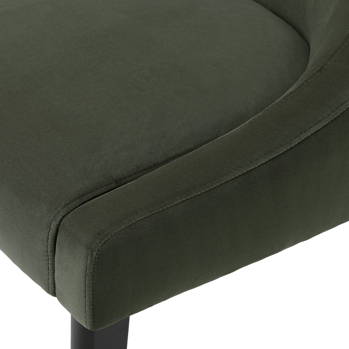 Close-up of the Chavelle dining chair Torrin green velvet seat edge and stitching
